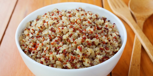 A bowl of cooked red, white and black quinoa and amaranth is shared at a table. White rice eaters can try switching to foods like this that offer better nutritional value.
