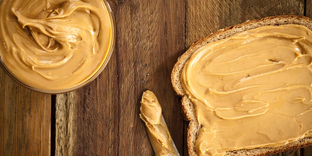 Peanut butter spread across a piece of bread. It's wise to swap any kind of nut butter — peanut, almond, sunflower and others — for unsalted and no-sugar-added nut butter, said one nutrition expert.