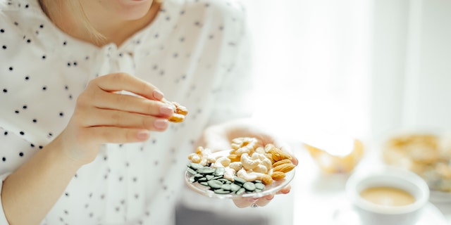 A woman indulges in a plate of nuts and seeds. "The goal is to improve soluble fiber, which a lot of us don't get these days."