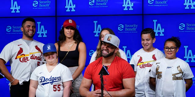 St. Louis Cardinals designated hitter Albert Pujols, center, is surrounded by his family while speaking to reporters after a baseball game against the Los Angeles Dodgers in Los Angeles, Friday, Sept. 23, 2022. Pujols hit his 700th home run during the fourth inning.