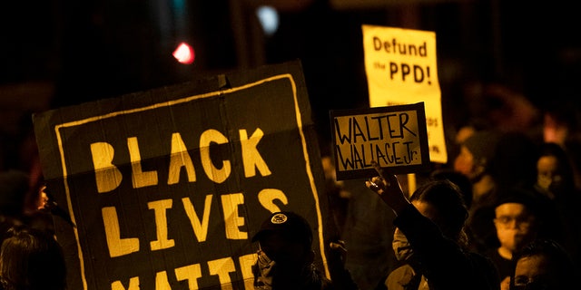 PHILADELPHIA, PA - OCTOBER 27: Demonstrators hold placards reading "BLACK LIVES MATTER," "Walter Wallace JR." and DEFUND PPD" as they gather in protest near the location where Walter Wallace, Jr. was killed by two police officers on October 27, 2020 in Philadelphia, Pennsylvania. Protests erupted after the fatal shooting of 27-year-old Wallace Jr, who Philadelphia police officers claimed was armed with a knife. (Photo by Mark Makela/Getty Images)