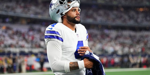 Dak Prescott #4 of the Dallas Cowboys uses a Gatorade towel to wipe his hand against the Tampa Bay Buccaneers at AT&T Stadium on September 11, 2022 in Arlington, TX.