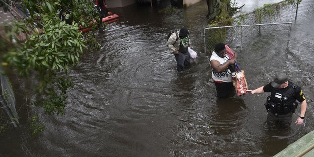 People are led to safety amid flooding in central Florida from Hurricane Ian.