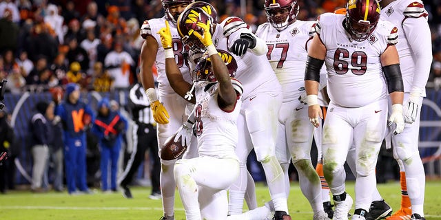 Brian Robinson #8 of the Washington Commanders celebrates his touchdown during the fourth quarter against the Chicago Bears at Soldier Field on October 13, 2022 in Chicago, Illinois.