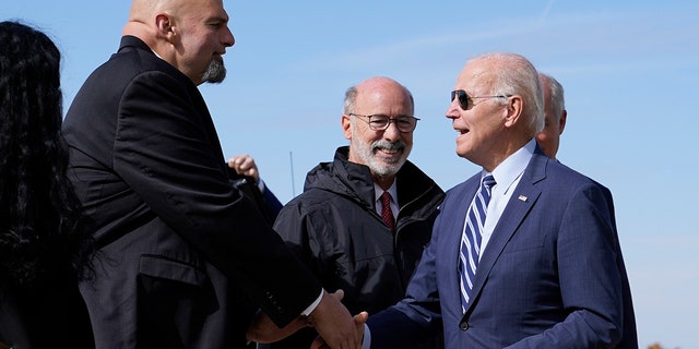 President Joe Biden speaks with Pennsylvania Lt. Gov. John Fetterman, a Democratic candidate for U.S. Senate, after stepping off Air Force One, Thursday, Oct. 20, 2022, at the 171st Air Refueling Wing at Pittsburgh International Airport in Coraopolis, Pa. Biden is visiting Pittsburgh to promote his infrastructure agenda.