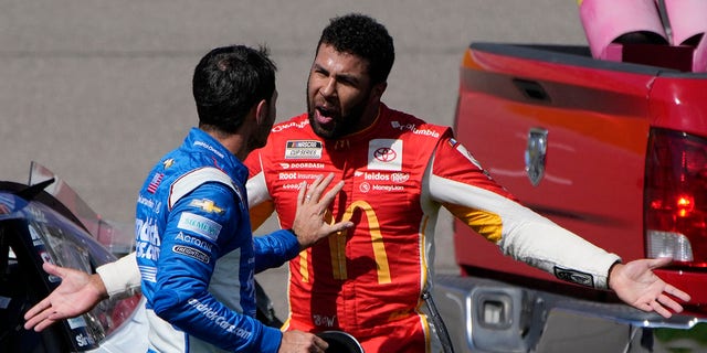 Bubba Wallace, right, argues with Kyle Larson after the two crashed during a NASCAR Cup Series auto race Sunday, Oct. 16, 2022, in Las Vegas.