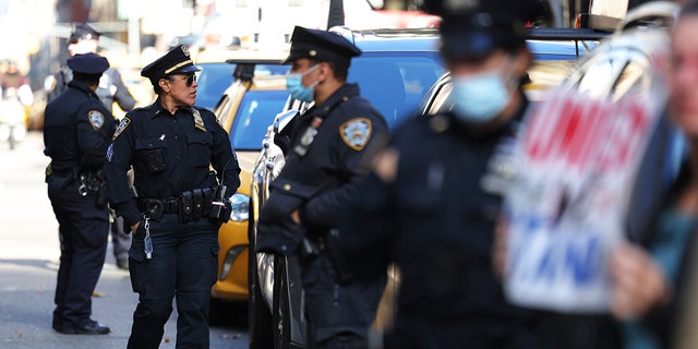 NYPD officers stand guard as people gather to protest vaccine mandates for city workers at City Hall Park on November 3, 2021, in New York City.