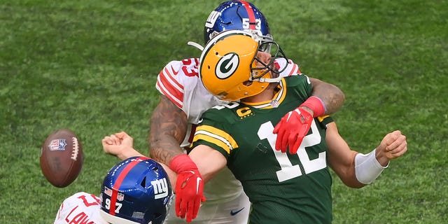 Aaron Rodgers of the Green Bay Packers is sacked by Oshane Ximines of the New York Giants and fumbles the ball during the fourth quarter at Tottenham Hotspur Stadium on Oct. 9, 2022, in London.